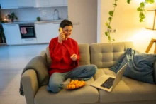 Žena telefonuje na gauči.