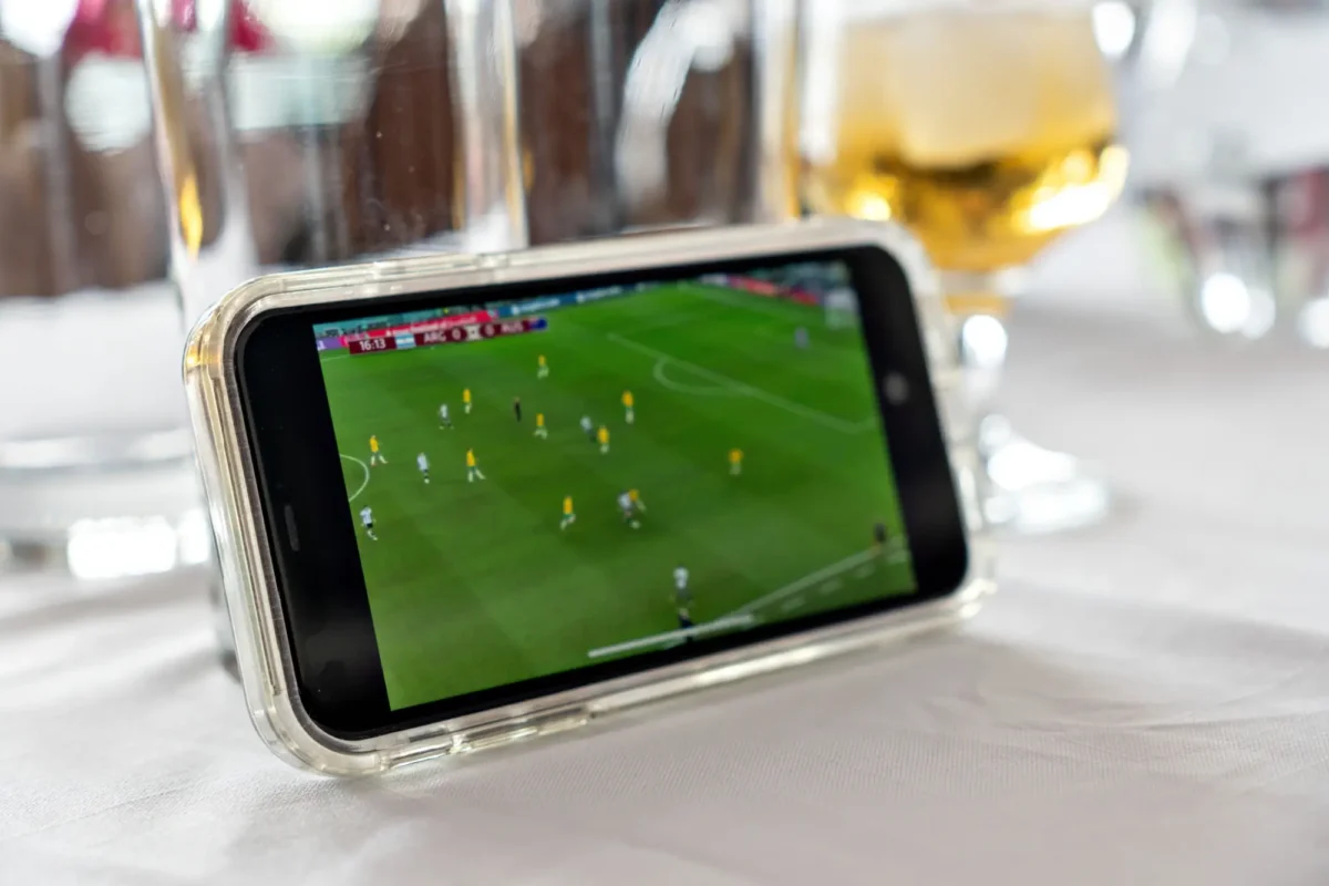 sledování fotbalu na mobilu v restauraci