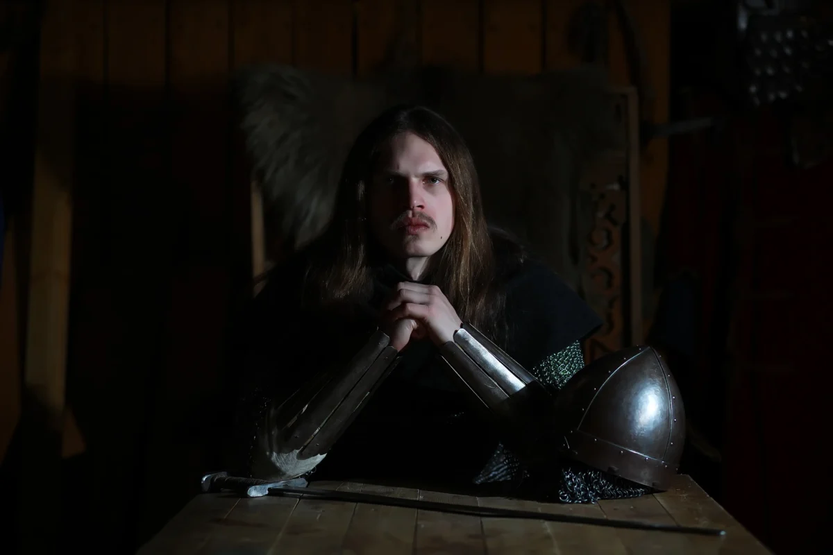 Voják sedí u helmy. 