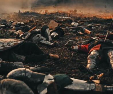 Středověcí vojáci leží na zemi.