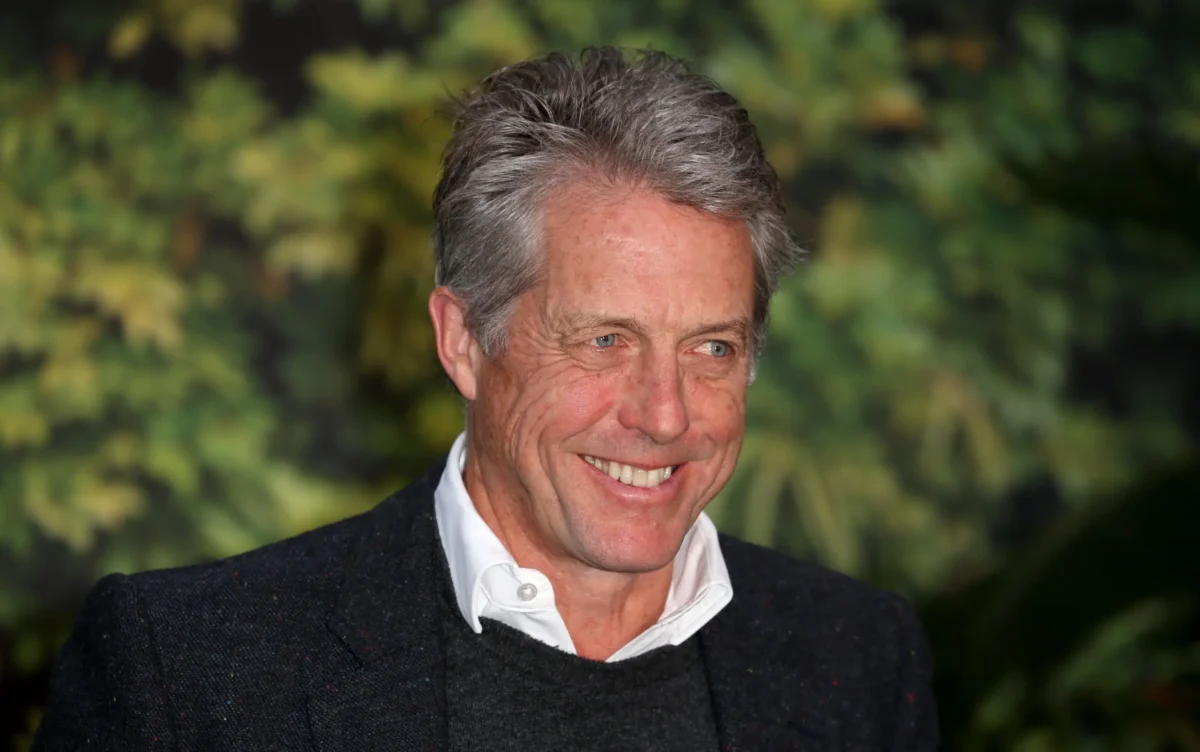 Hugh Grant se usmívá.