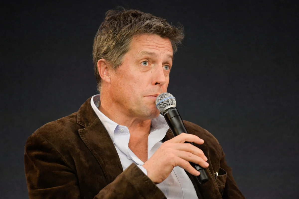 Hugh Grant mluví do mikrofonu.