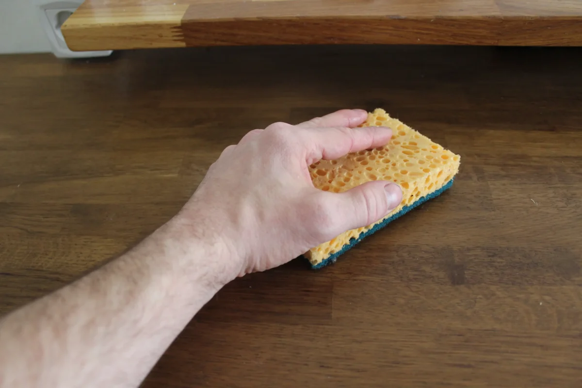 Člověk uklízí pomocí houbičky. 