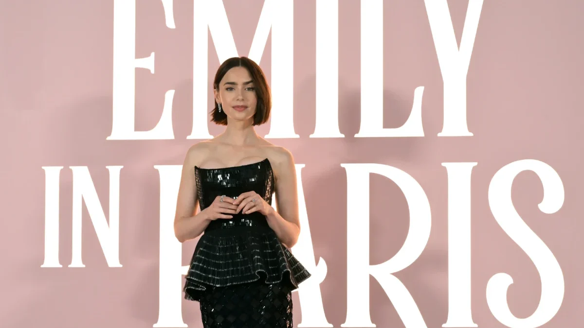 Lily Collins stojí u nápisu Emily in Paris.