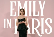 Lily Collins stojí u nápisu Emily in Paris.