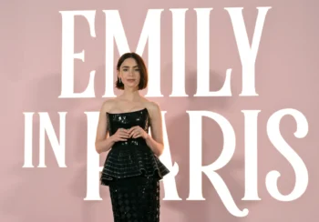 Lily Collins stojí u nápisu Emily in Paris.
