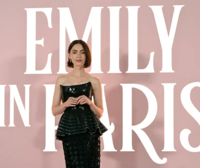 Lily Collins stojí u nápisu Emily in Paris.