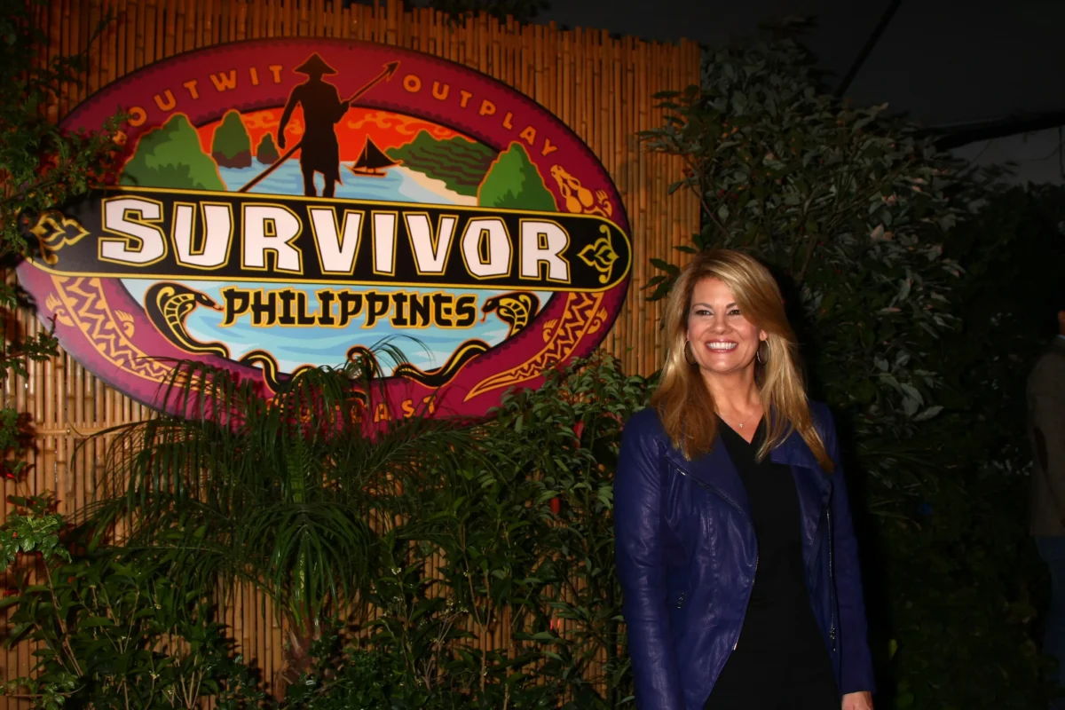 Žena stojí u nápisu Survivor.