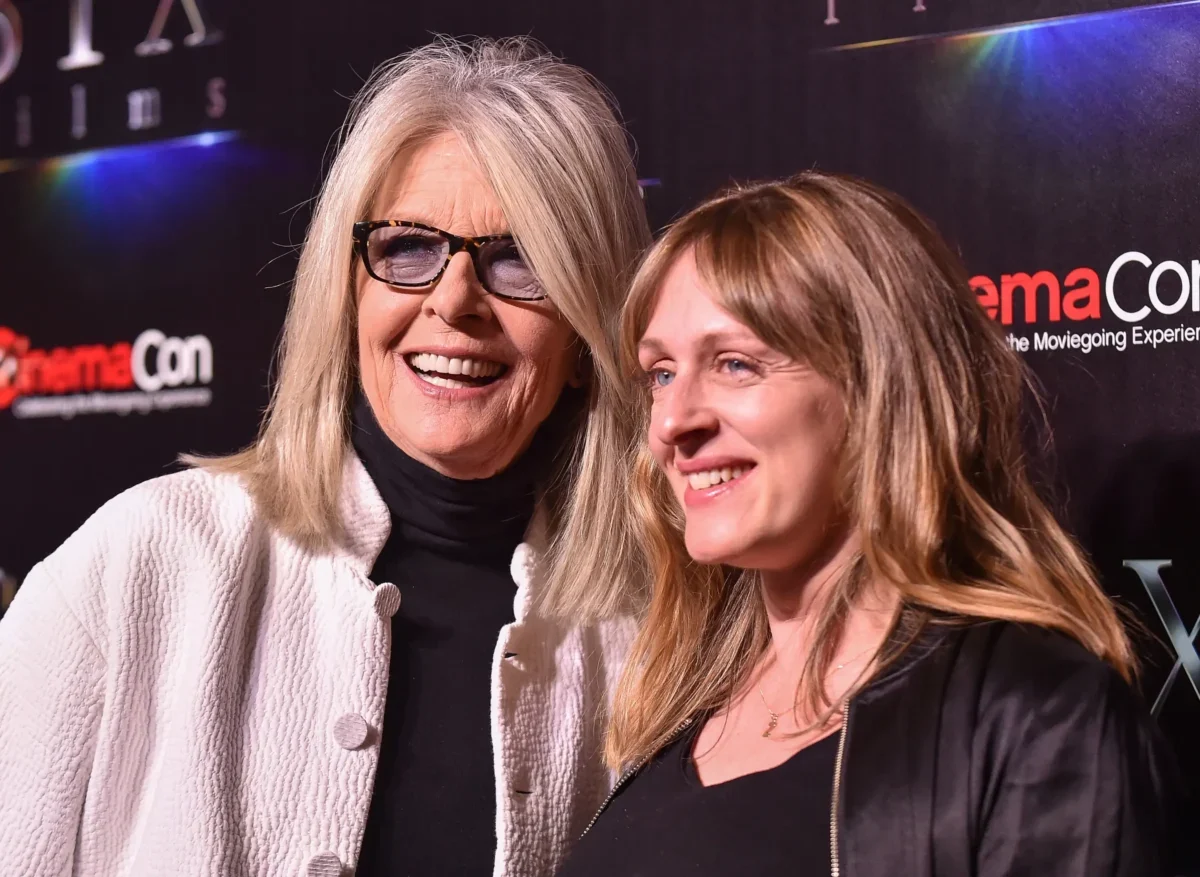 Diane Keaton stojí vedle jiné ženy.