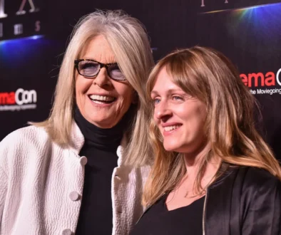 Diane Keaton stojí vedle jiné ženy.