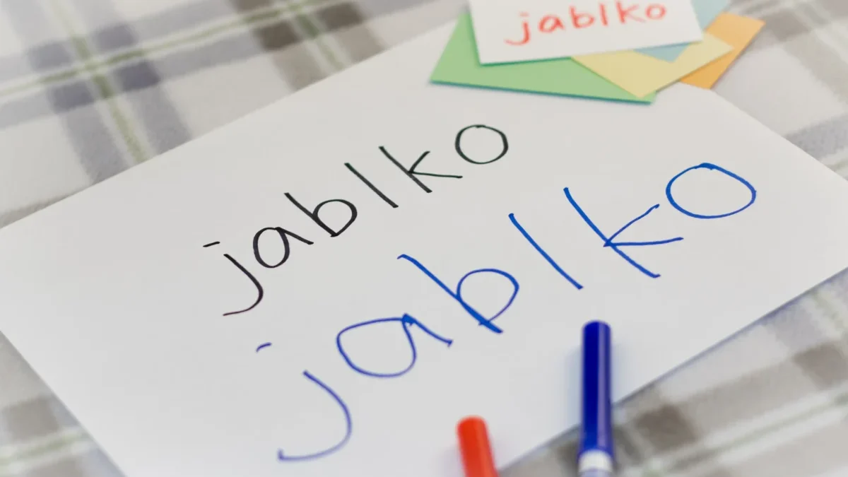 Na papíru je napsané slovo jablko.