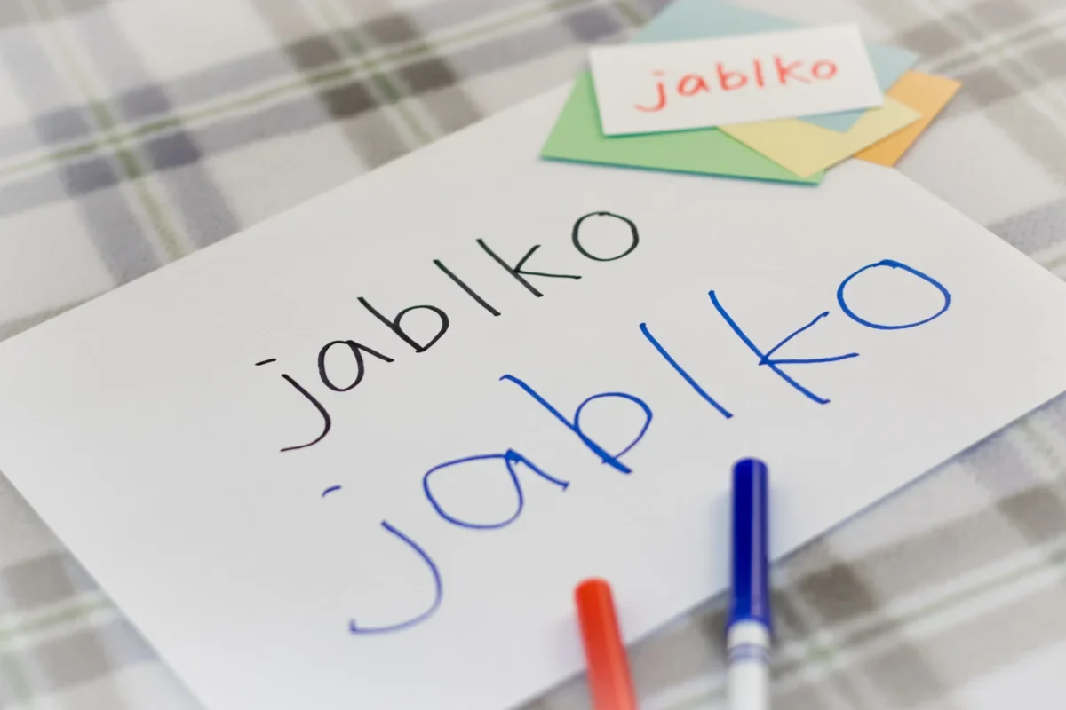 Na papíru je napsané slovo jablko.