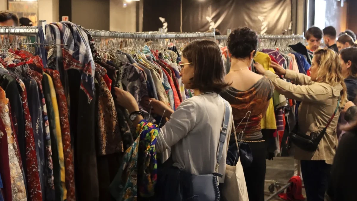 Lidé se přehrabují oblečením.