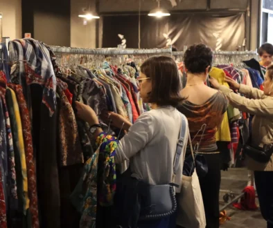 Lidé se přehrabují oblečením.