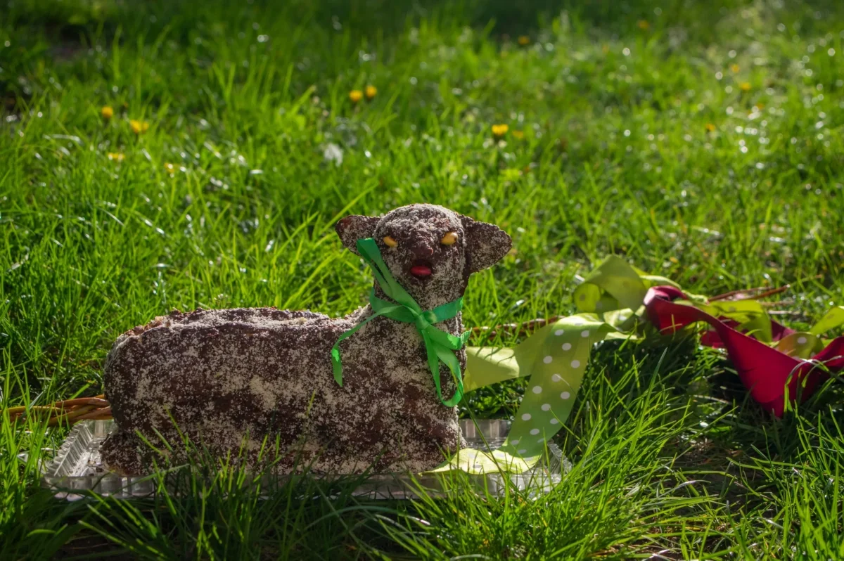 Na trávě leží velikonoční beránek.