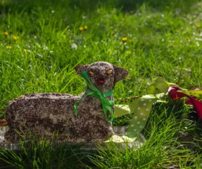 Na trávě leží velikonoční beránek.