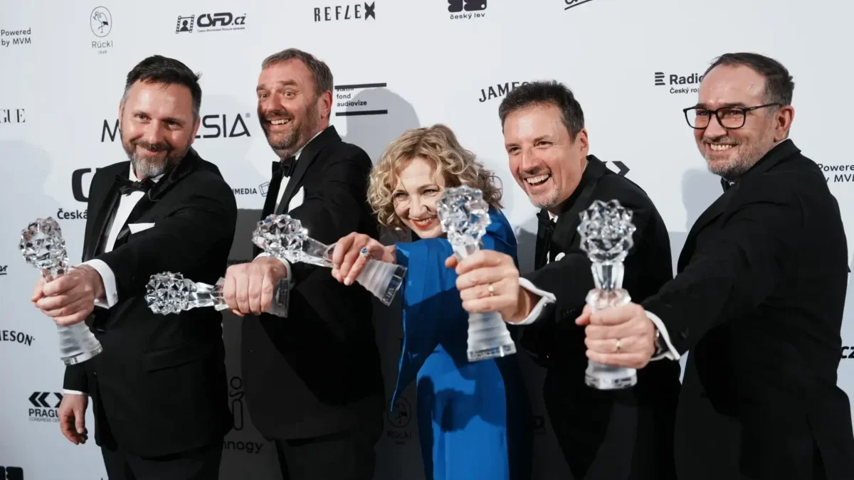 Lidé stojí vedle sebe a drží ocenění.