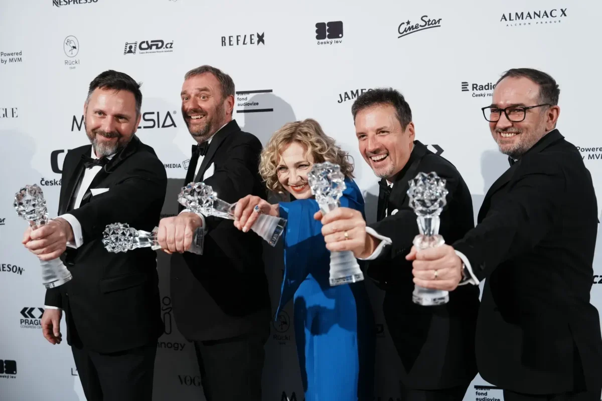 Lidé stojí vedle sebe a drží ocenění.
