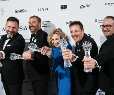 Lidé stojí vedle sebe a drží ocenění.