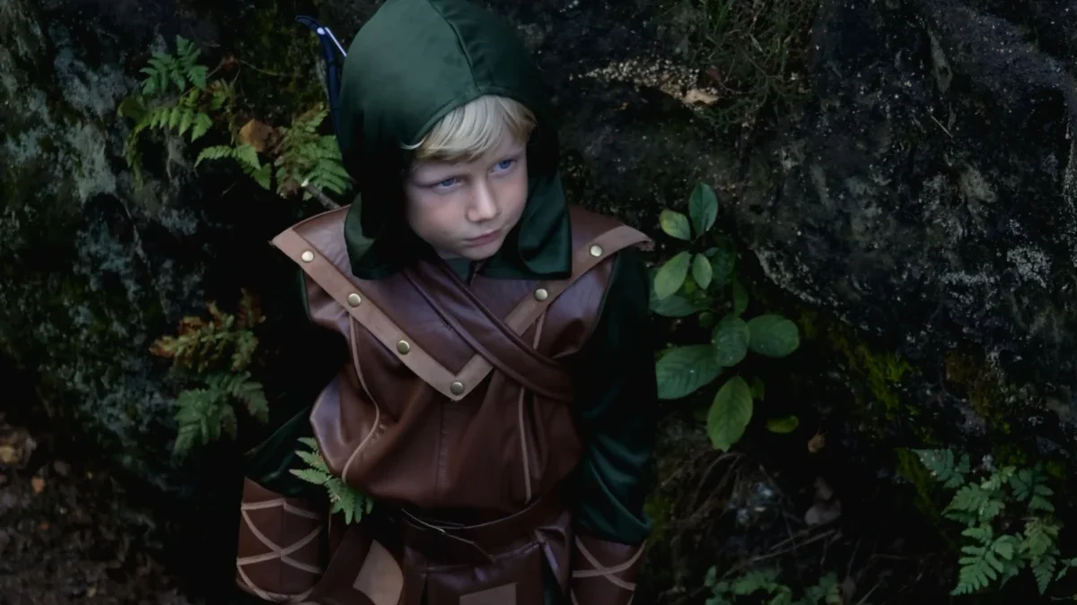 Malý chlapec je oblečený jako Robin Hood.