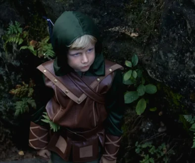 Malý chlapec je oblečený jako Robin Hood.