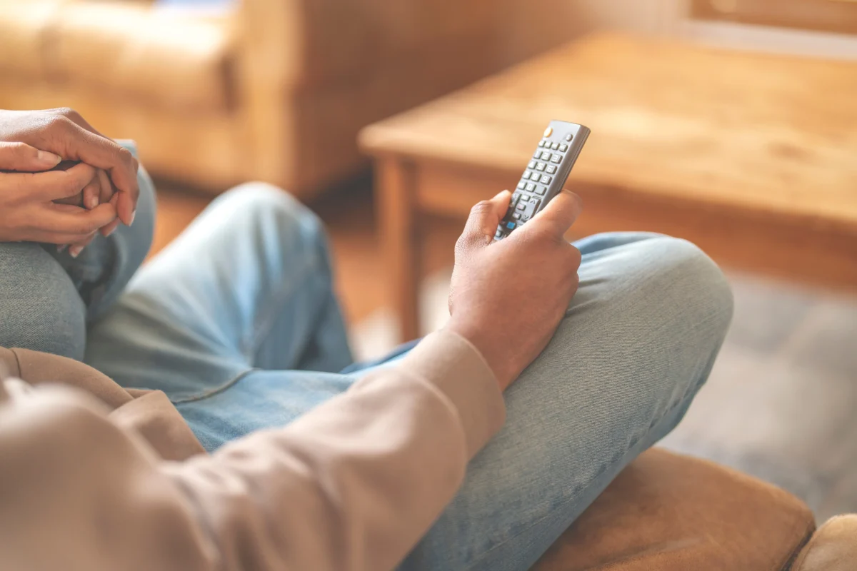 muž drží televizní ovladač