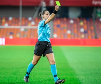 Rozhodčí v ruce drží kartu.