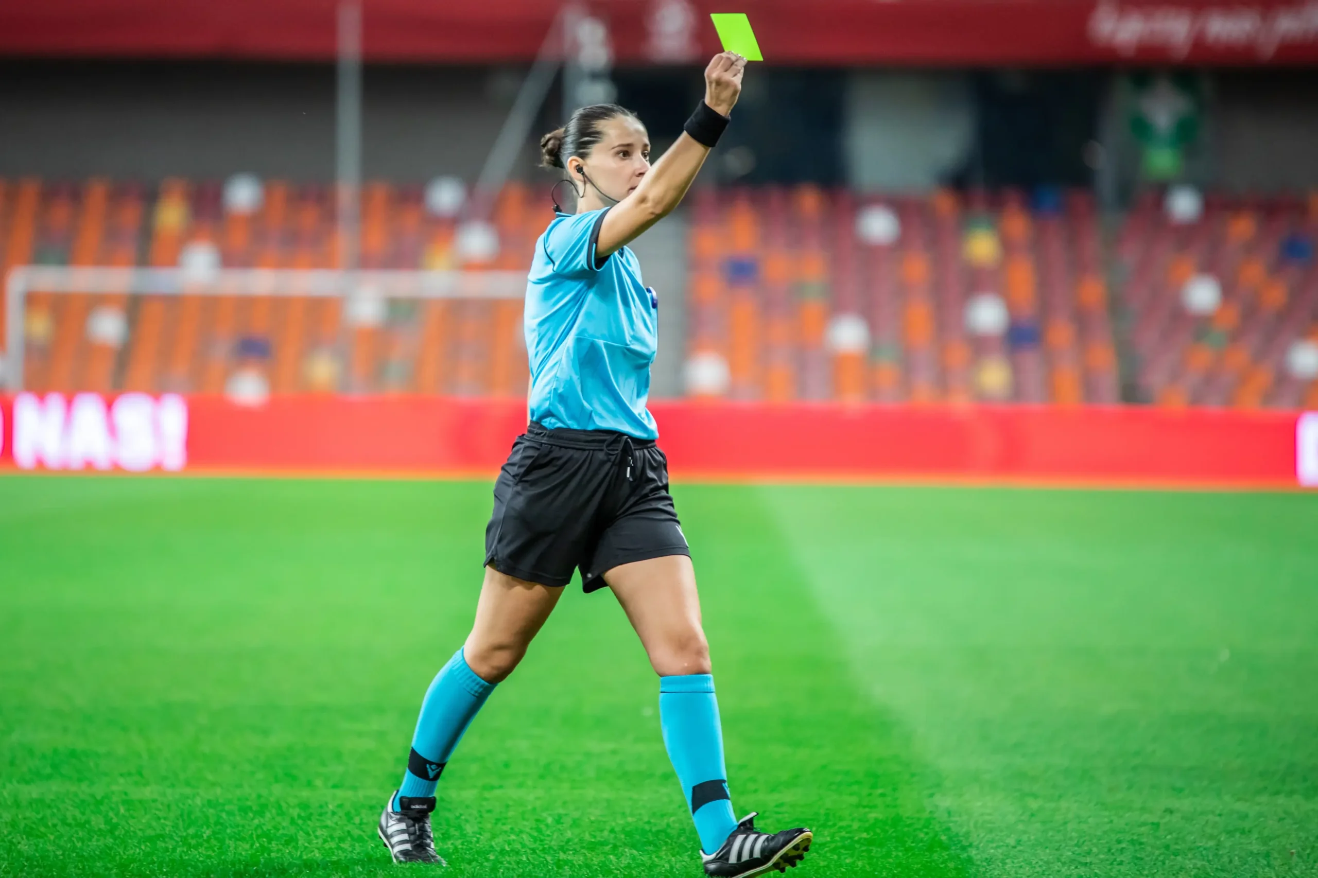 Rozhodčí v ruce drží kartu.