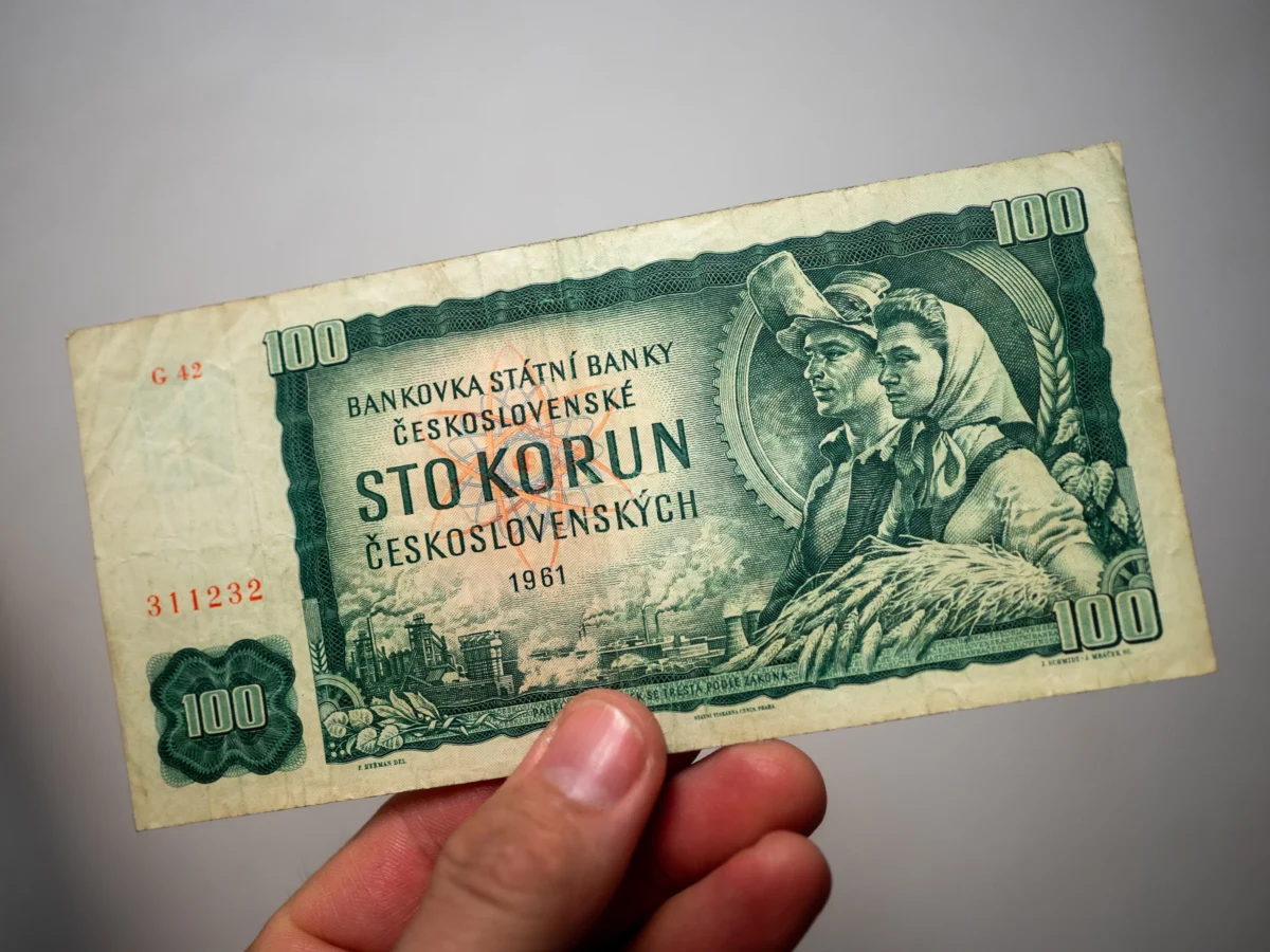 Člověk v ruce drží československou bankovku. 