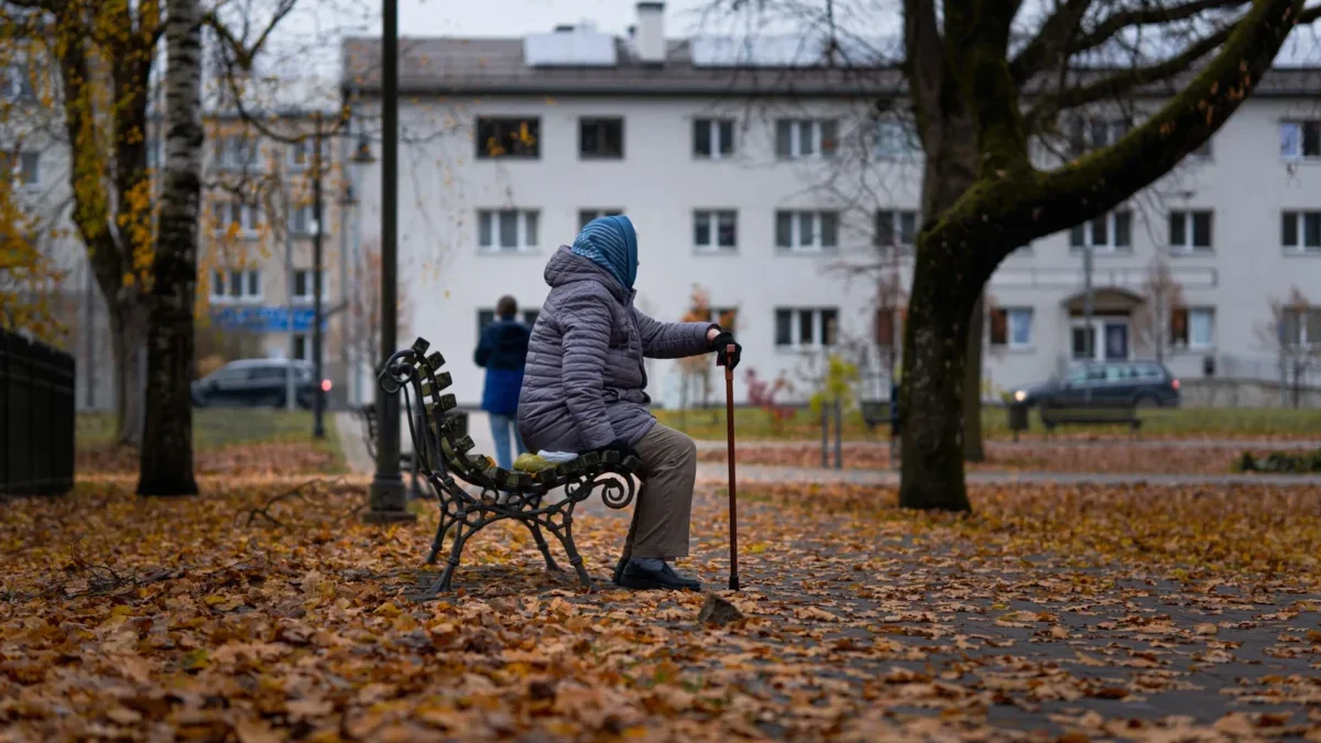 Babička sedí na lavičce.