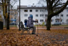 Babička sedí na lavičce.