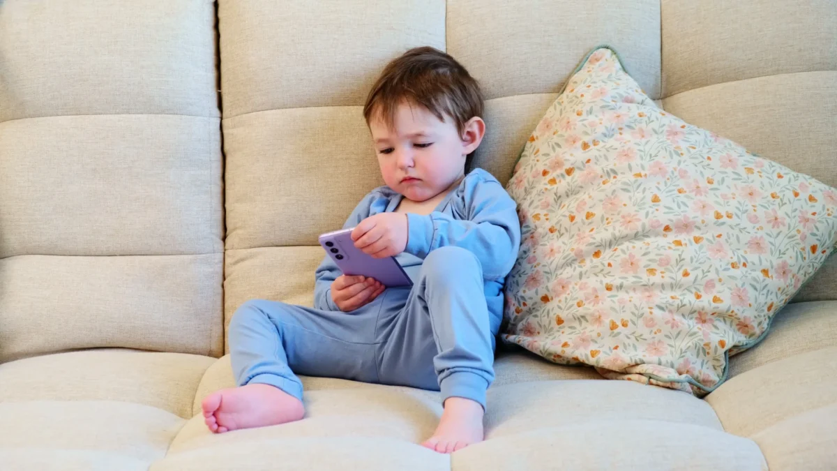 Malé dítě s telefonem v ruce.