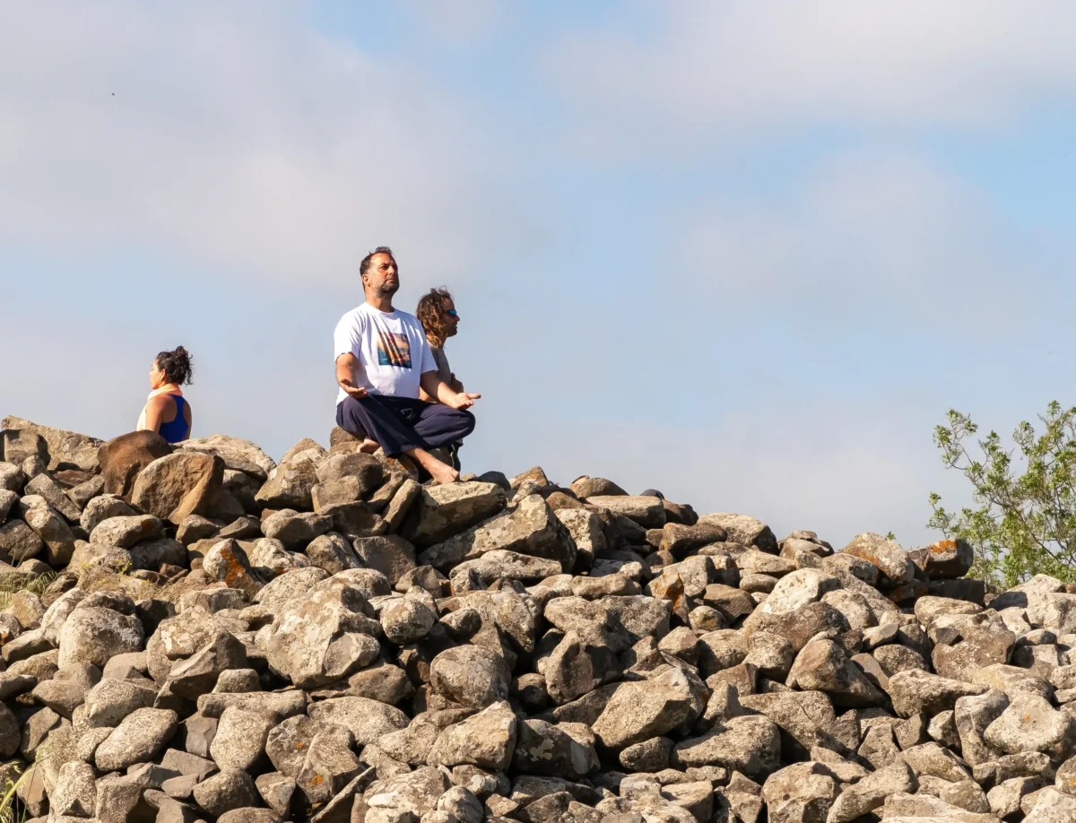 Lidé meditují na kamenech.