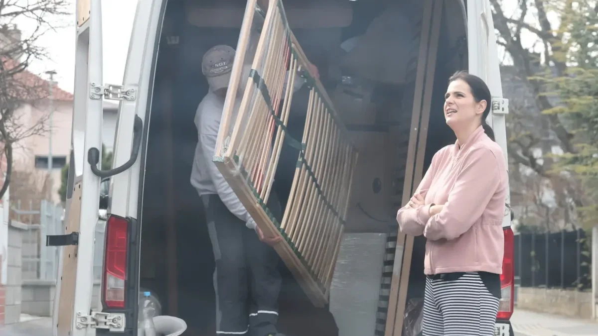 Ornella Koktová stojí u auta, ze kterého muž tahá rošt.