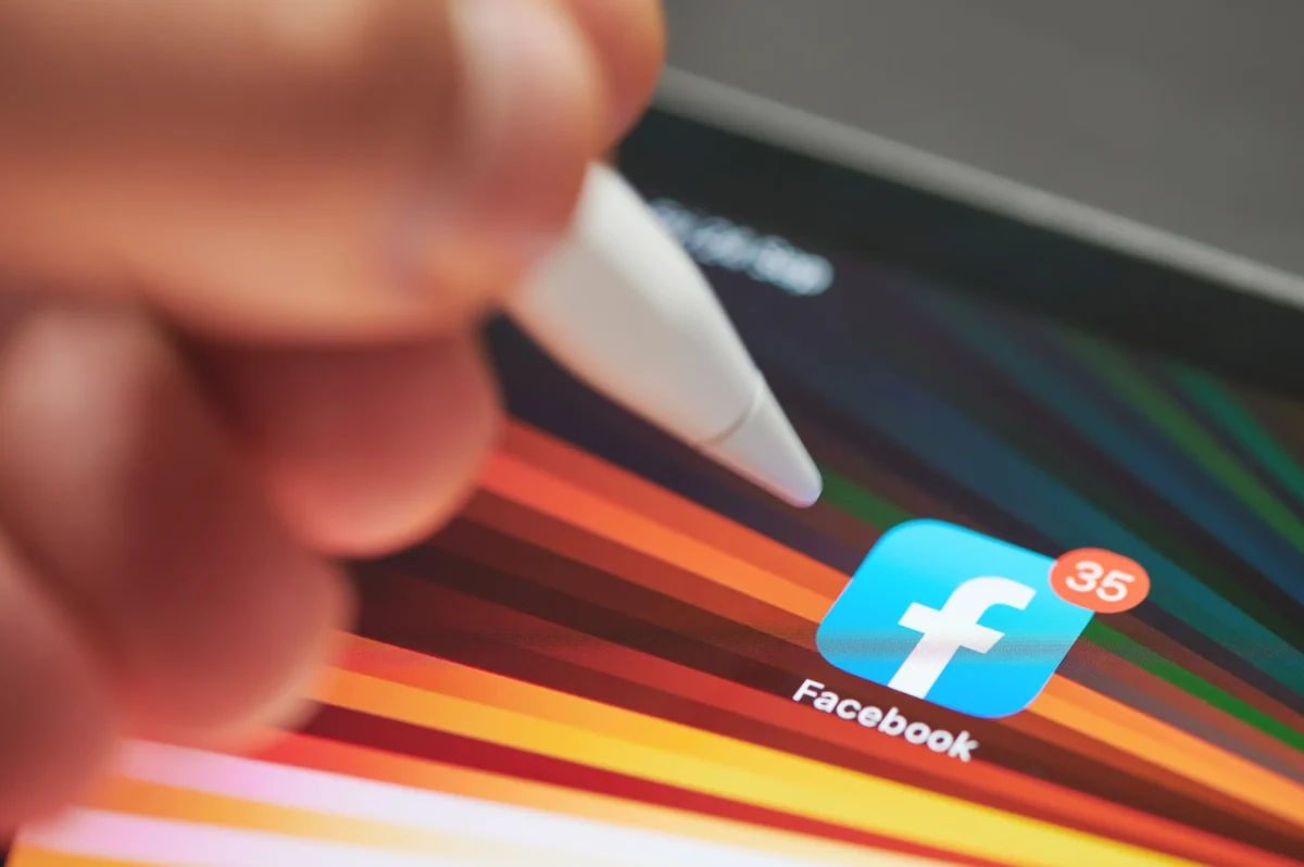 Člověk se chystá kliknout na ikonu Facebooku.