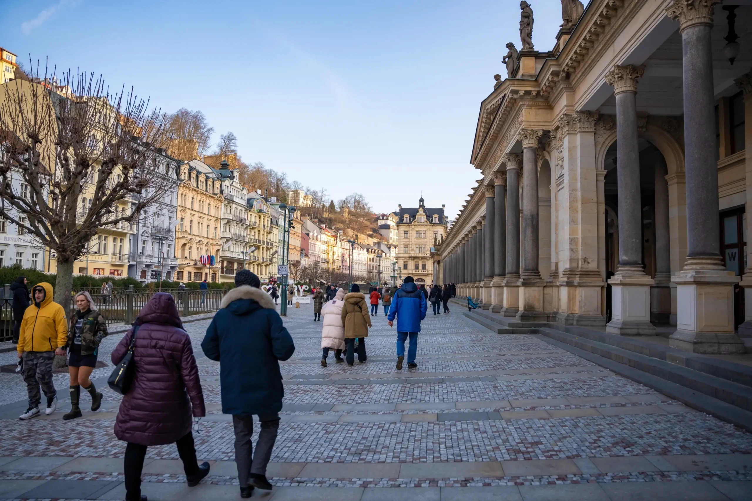 Lidé se procházejí po kolonádě.