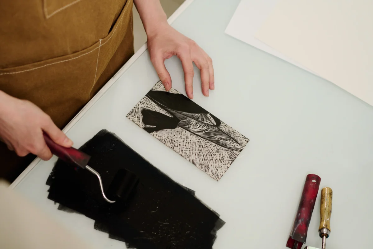 Žena něco podle předlohy vyrývá. 