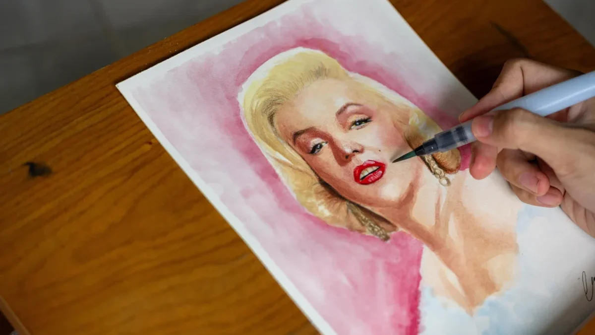 Člověk maluje Marilyn Monroe.