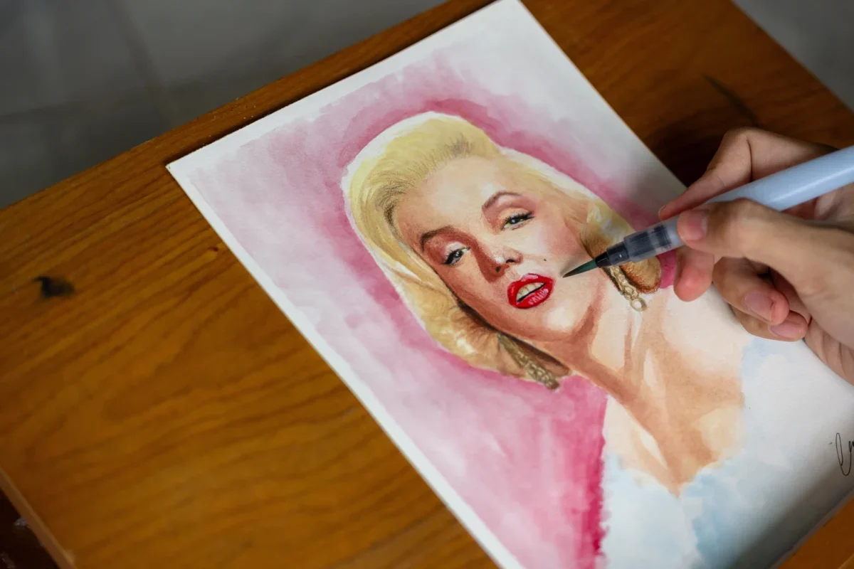 Člověk maluje Marilyn Monroe.