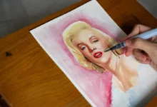 Člověk maluje Marilyn Monroe.