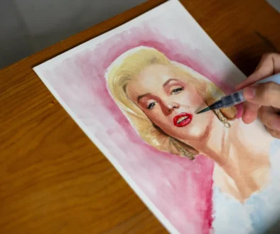 Člověk maluje Marilyn Monroe.