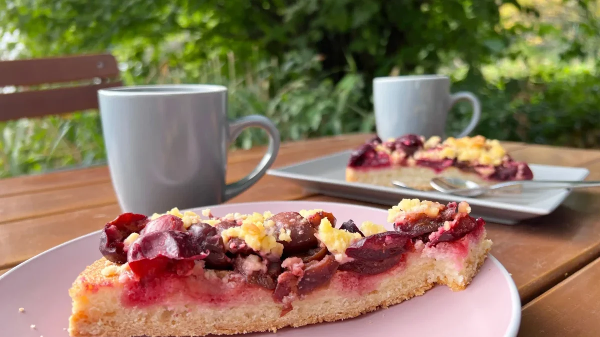 dva hrnky s čajem a kus koláče s červenými plody