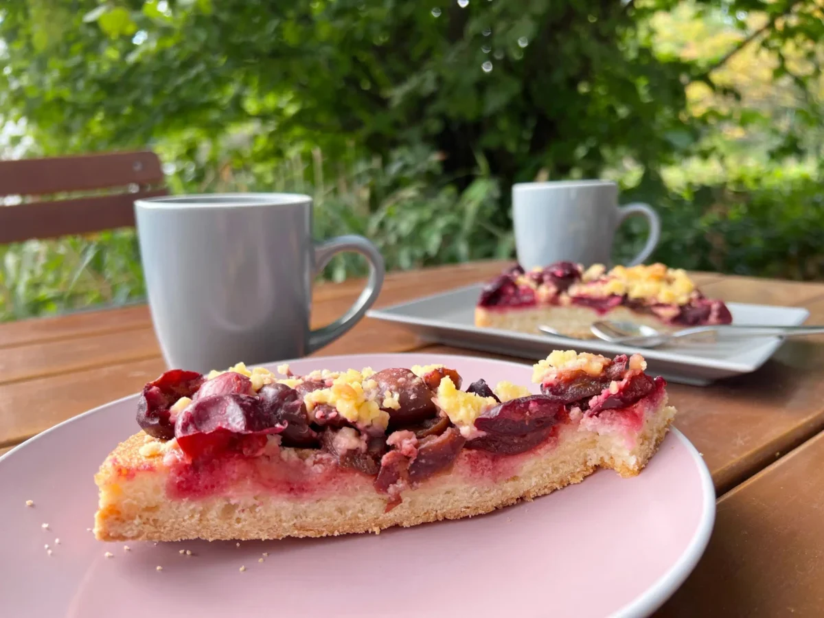 dva hrnky s čajem a kus koláče s červenými plody