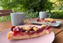 dva hrnky s čajem a kus koláče s červenými plody