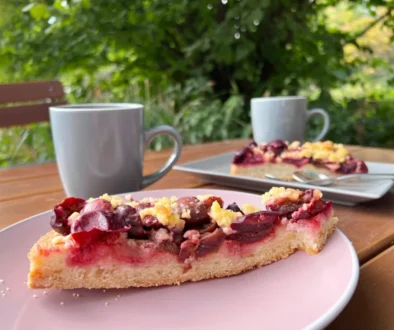 dva hrnky s čajem a kus koláče s červenými plody