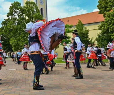Lidé vystupují v krojích.