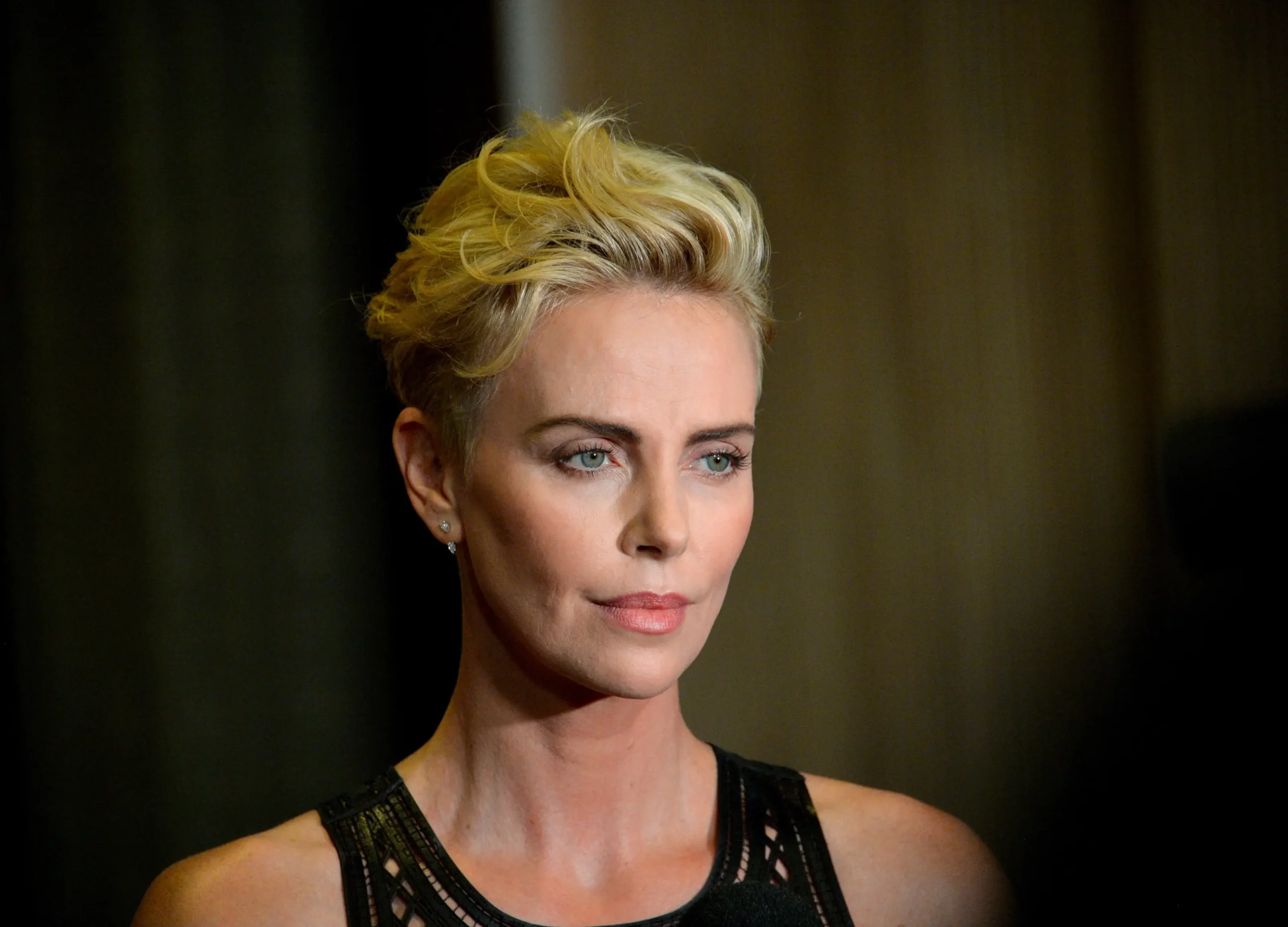 Charlize Theron se dívá do strany.