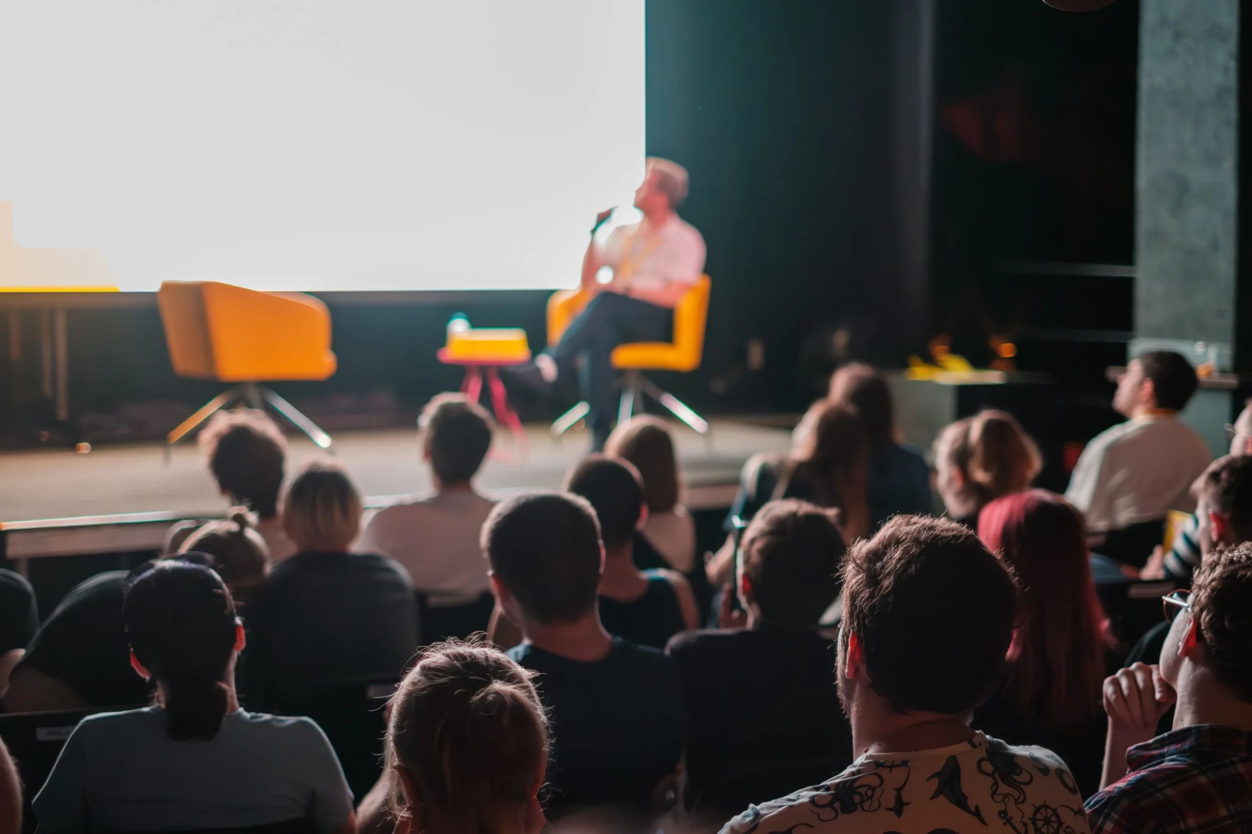 Divadelní sál s hosty na pódiu 