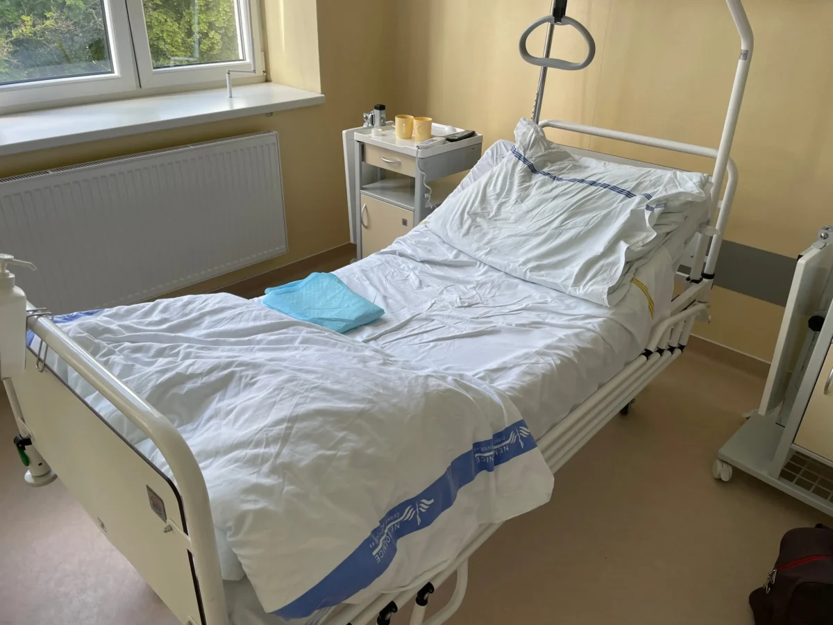 Postel v nemocničním pokoji. 