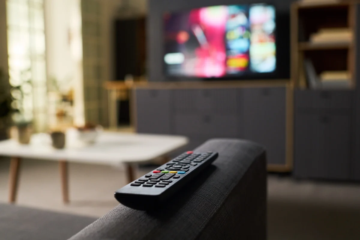 Na gauči leží ovladač od TV.